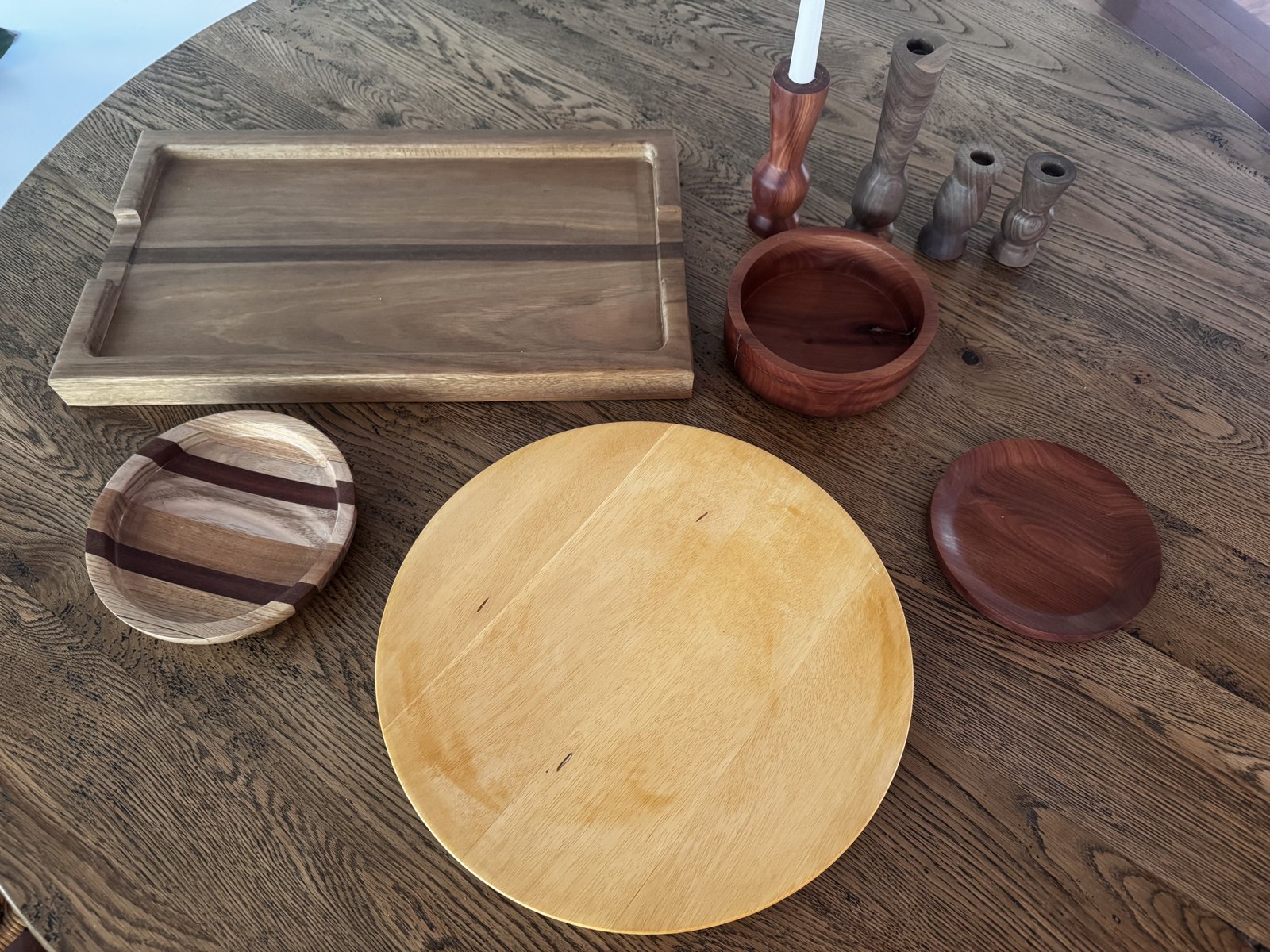 A collection of hand-turned bowls, platters, a serving board and candlestick holders