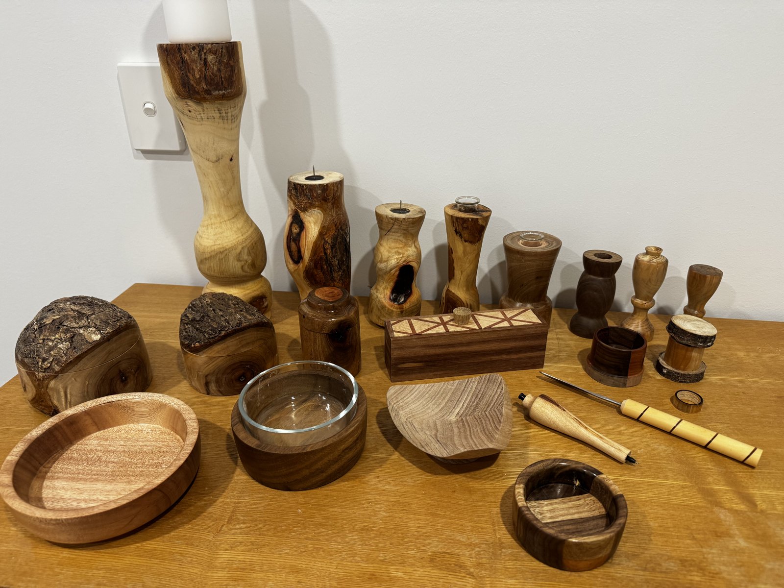 A table of small hand-turned pieces — boxes, bowls, candlesticks and more